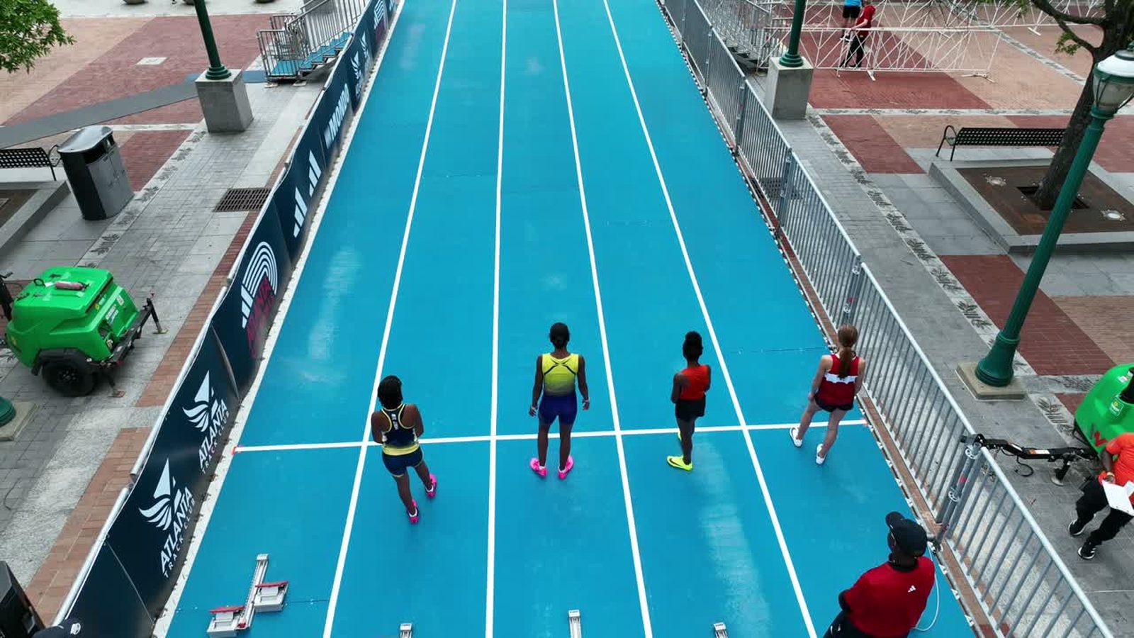 Aerial view of athletes and spectators around a blue running track