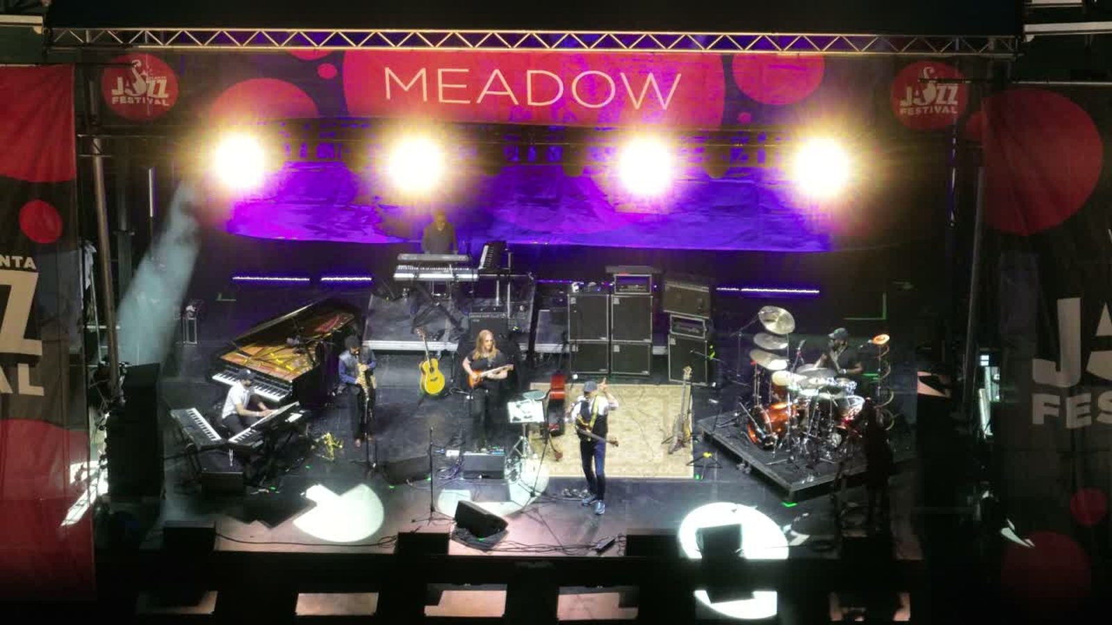 Aerial view of a lit outdoor concert stage during a performance