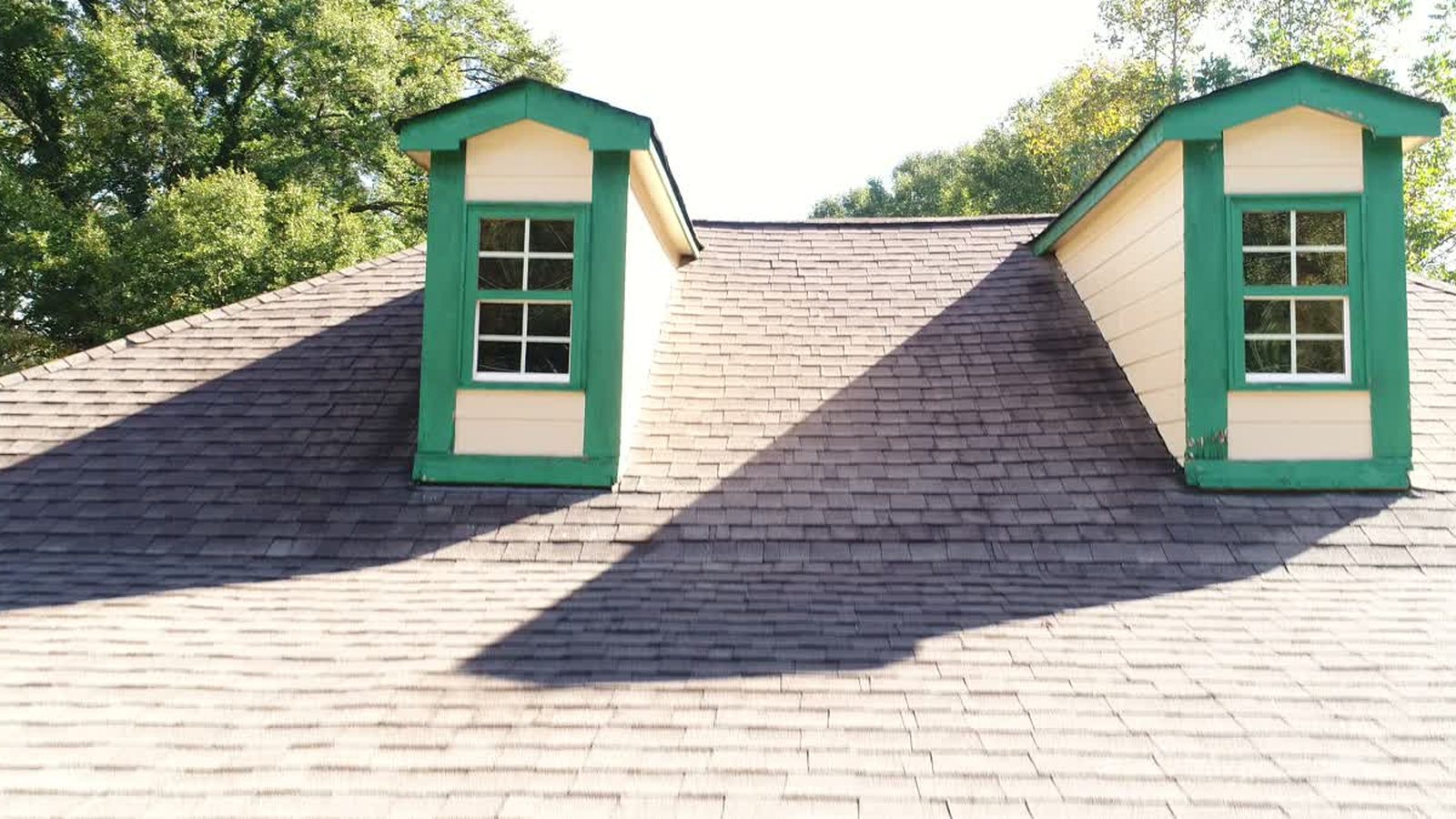 Close aerial view of shingled dormers and roof valleys on a house